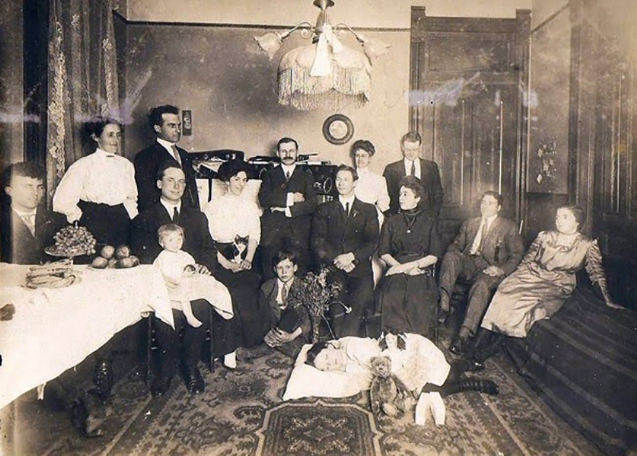 Dead girl is is lying on the floor of the parlor surrounded by family members.