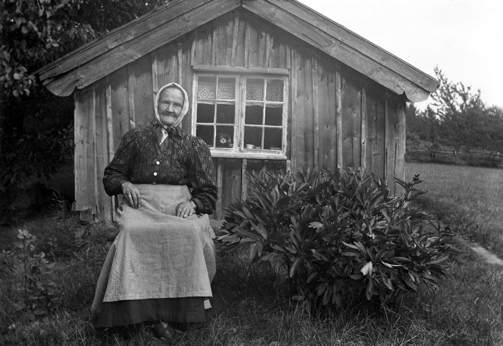 Grandmother sitting in front of her cottage.