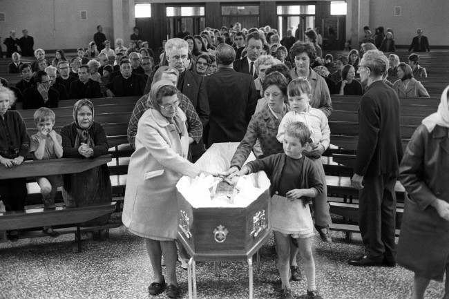 Mourners file past the coffin of Father Hugh Mullan, at Corpus Christi Roman Catholic Church on the Ballymurphy estate after Requiem Mass, 11 Aug, 1971