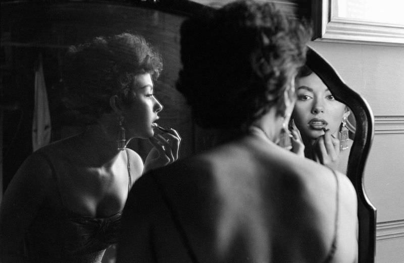 Rita Moreno puts on makeup in the mirror, Hollywood, 1954.