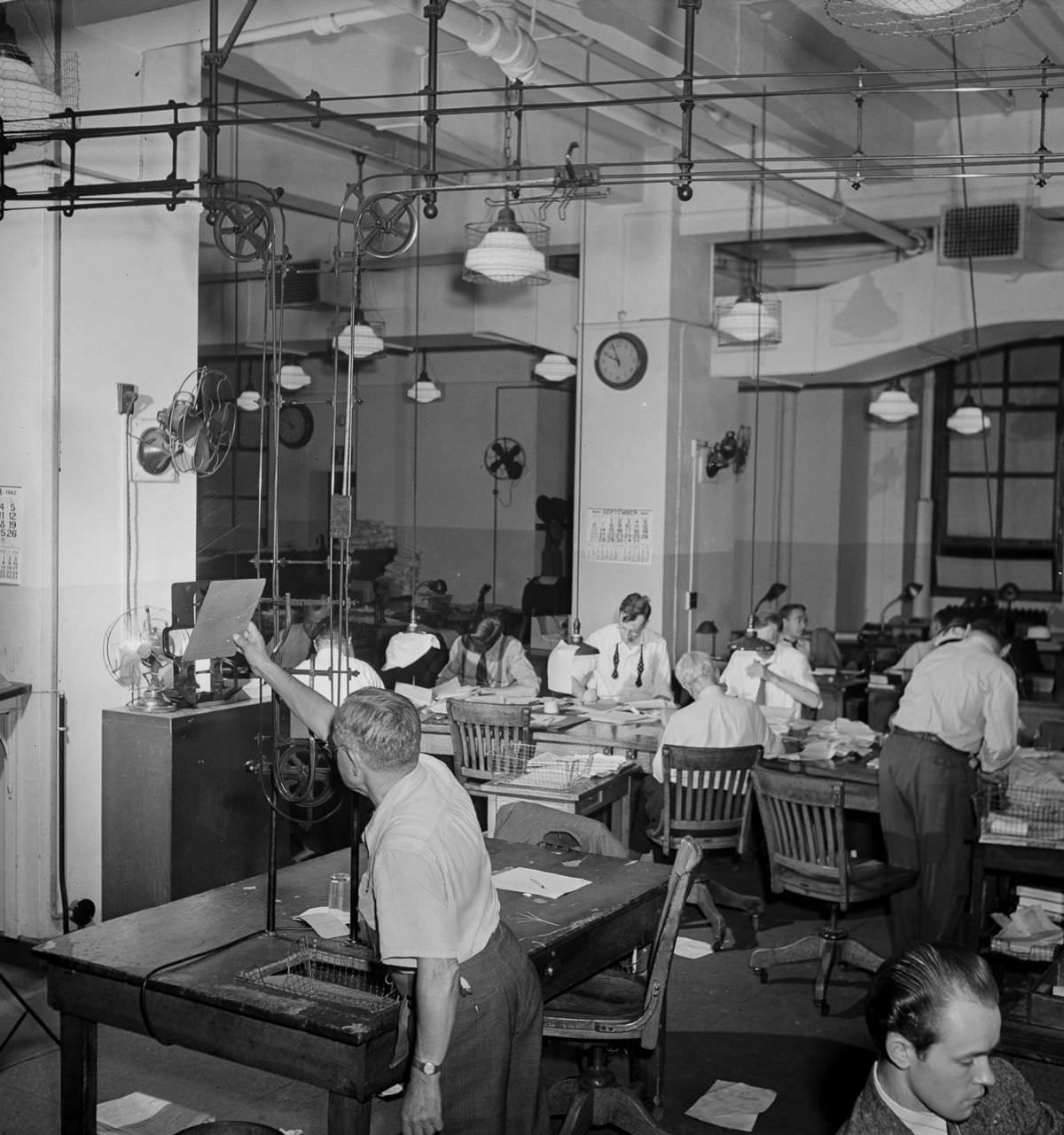 The newsroom: a conveyor belt carries completed copy up to the composing room.