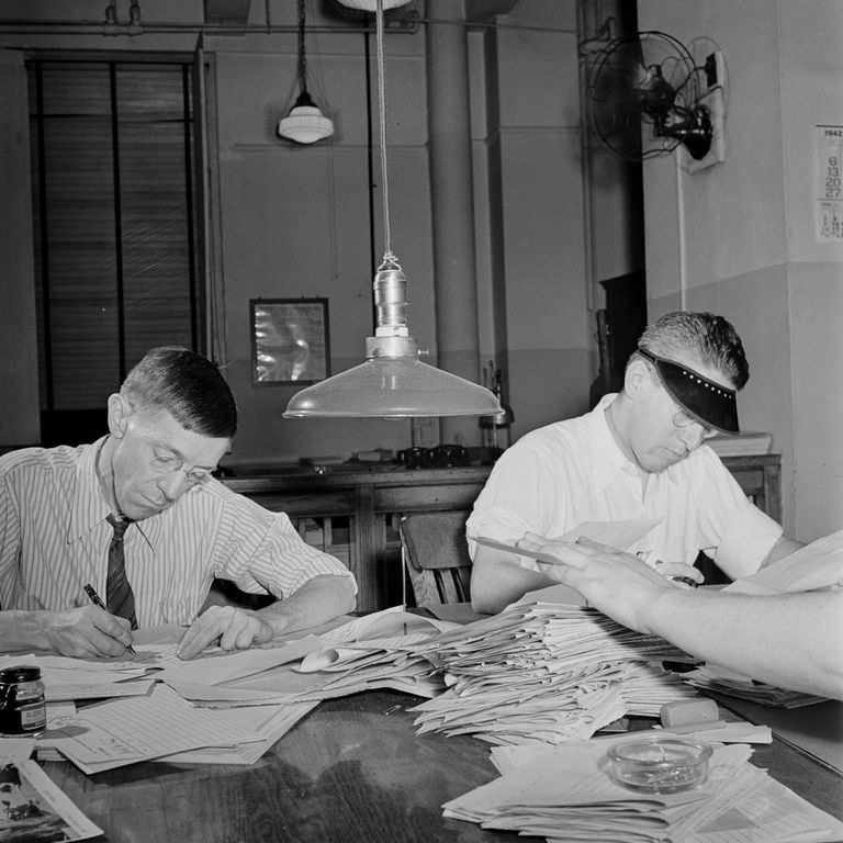 Copyreaders at the foreign desk in the newsroom. In the foreground, the foreign editor discards a story by "spiking" it.