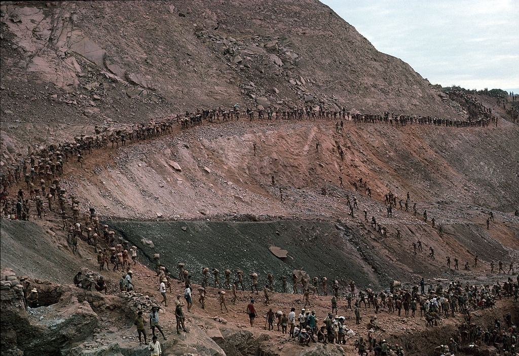 Mine workers, or garimpeiros, carry out 40-pound bags of ore from their owners mining claims July 15, 1985 in Serra Pelada, Brazil.