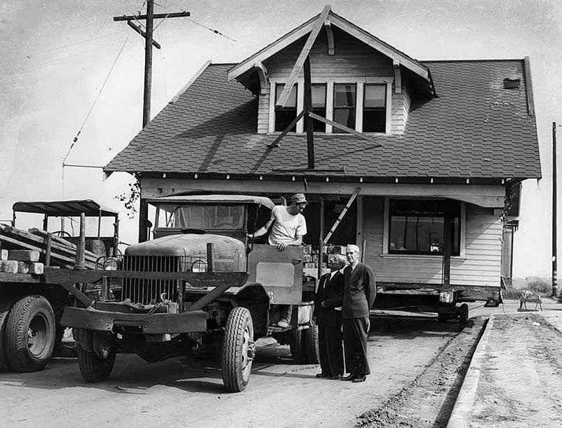 The parsonage of Inglewood First Methodist Church is moved to Grace Methodist Church in Lennox. Ed French, left, the foreman on the moving job, talks with Rev. M.K. Stone and Willis L. Hanna of Lennox. Oct. 25, 1950