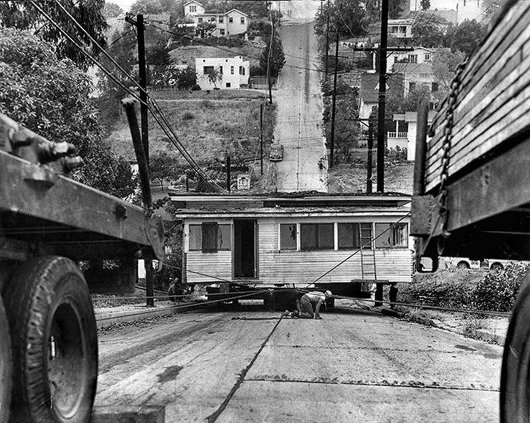 Cables are used to pull a six-room, 20-ton house up a hill – one of the steepest in town – on Baxter Street, just east of Lake Shore Avenue, in Silver Lake. July 10, 1951