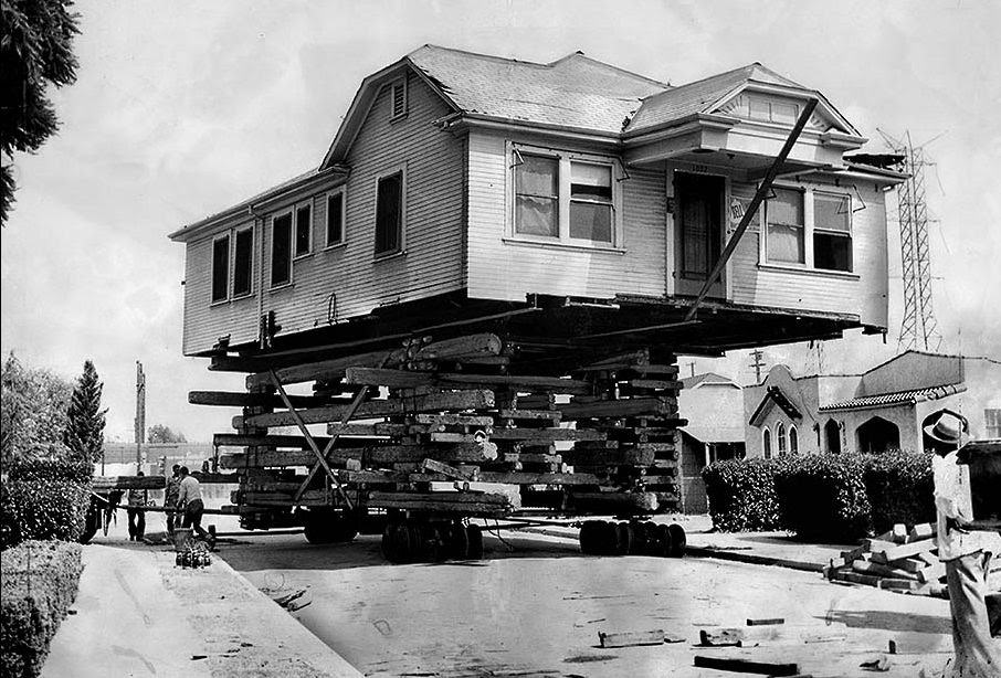 A house being transported on the back of a truck in the LA city.