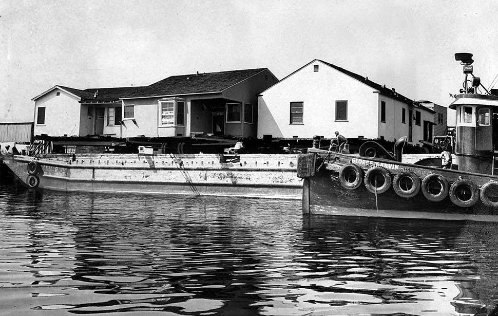 A barge carrying a pair of houses is prepared to sail from Los Angeles Harbor to Port Hueneme in Ventura County. Aug. 23, 1960