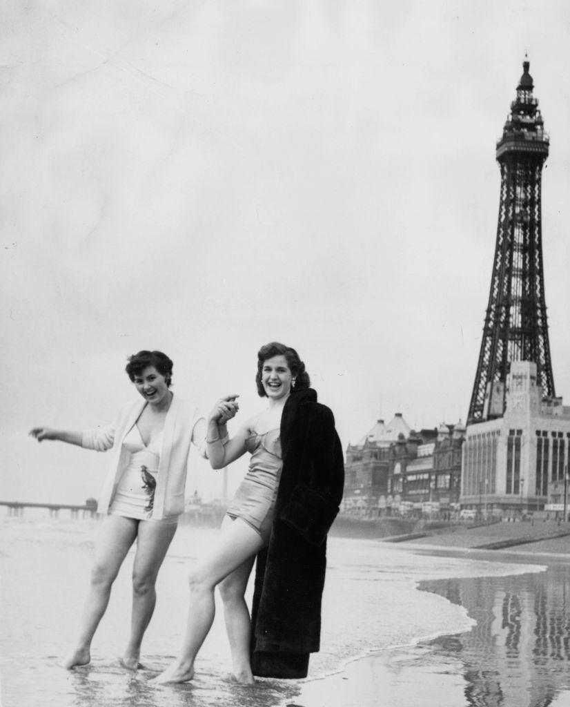 Two young women from Blackpool tentatively paddling at the water's edge, 1954.