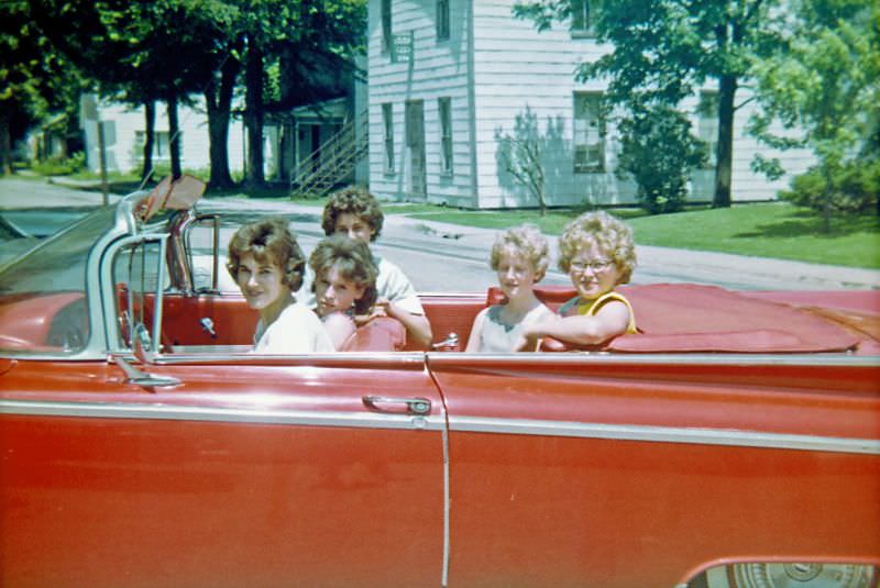 A group of teenage girls take a spin in a red convertible