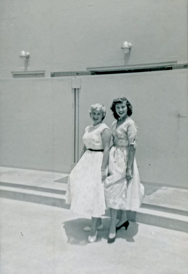 Two girls in dresses pose