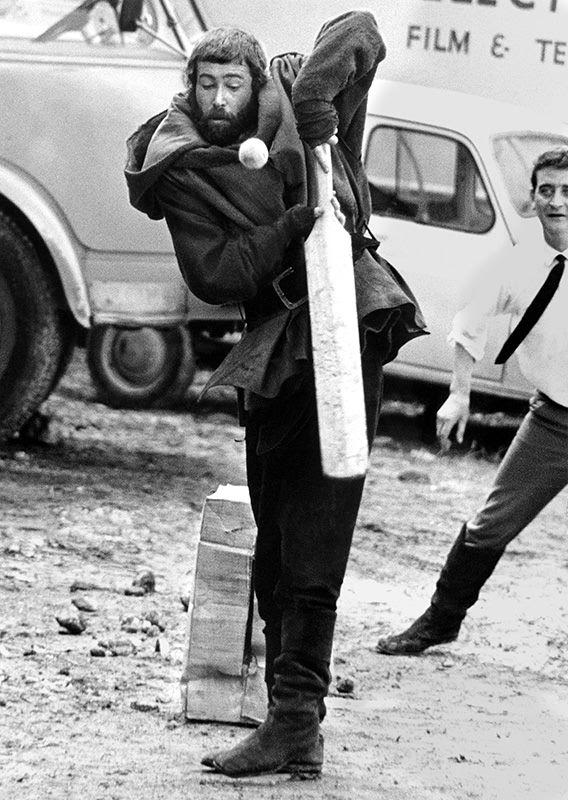 Peter O'Toole dressed for his role as King Henry II, tries his hand at cricket on the French location for "The Lion in Winter 1967