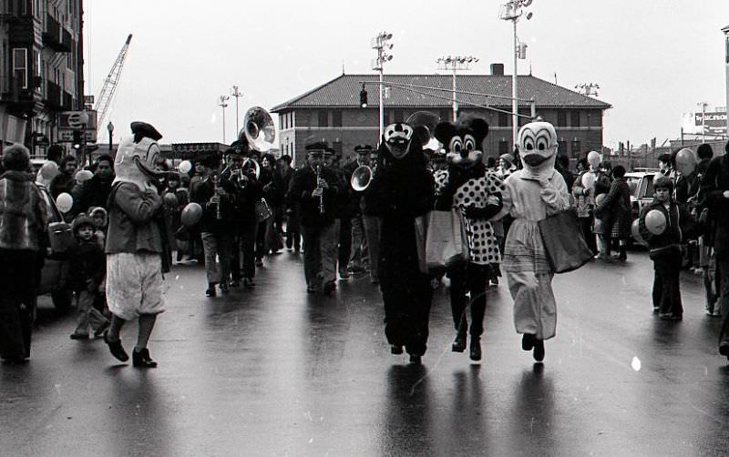 Characters in costume including Minnie Mouse and Donald Duck marching in North End Christmas Parade