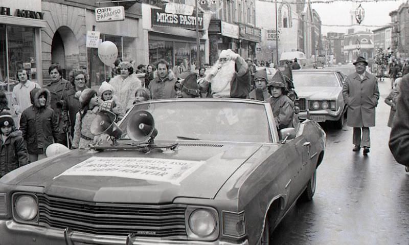 Santa Claus in car with children dressed as elves in North End Christmas Parade on Hanover Street