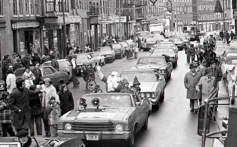 Santa Claus in car with children dressed as elves in North End Christmas Parade on Hanover Street