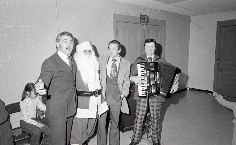 Accordion player and other men with Santa Claus at City Hall after North End Christmas Parade and Party