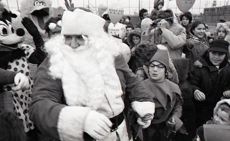 Santa Claus with the crowd and other costumed individuals at North End Christmas Party and Parade