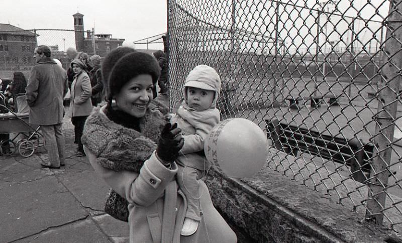 Woman holding a child at North End Christmas Party and Parade