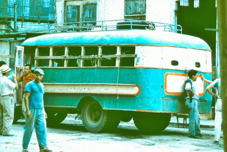 Ecuador. Bus between Cuenca and Pasaje. People in front, cows in rear, chickens on top, 1959