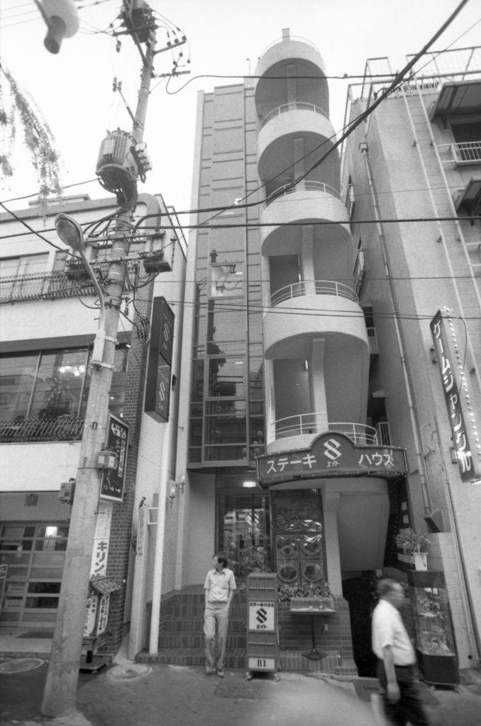 The strange building with the "8" in front is Capsule Hotel Eight, located near the big Ueno railroad station in Tokyo.