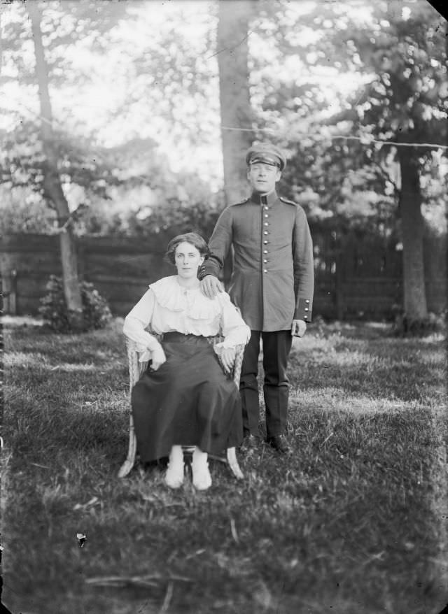 Woman in a chair with a man in the uniform of the German internees from the internment camp on the Breelaan, 1916