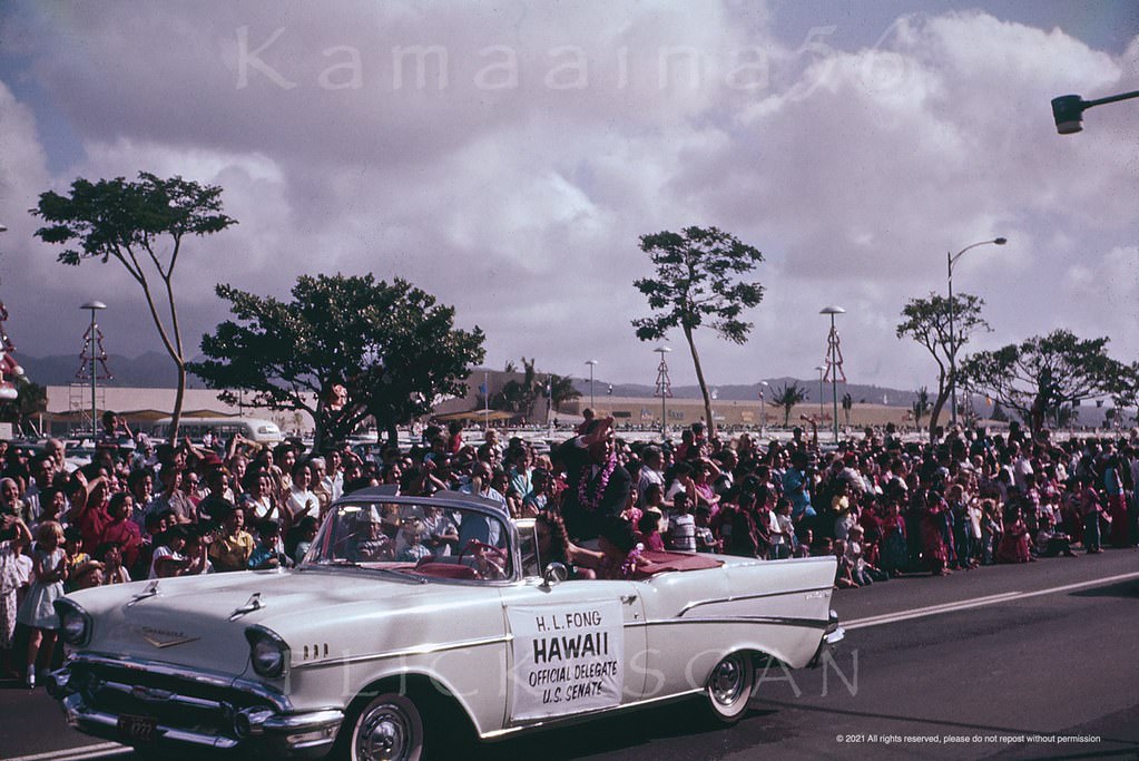 Long time Honolulu businessman and Republican Senator Hiram L. Fong (1906-2004) in a Christmas parade with Ala Moana Center in the background, 1959