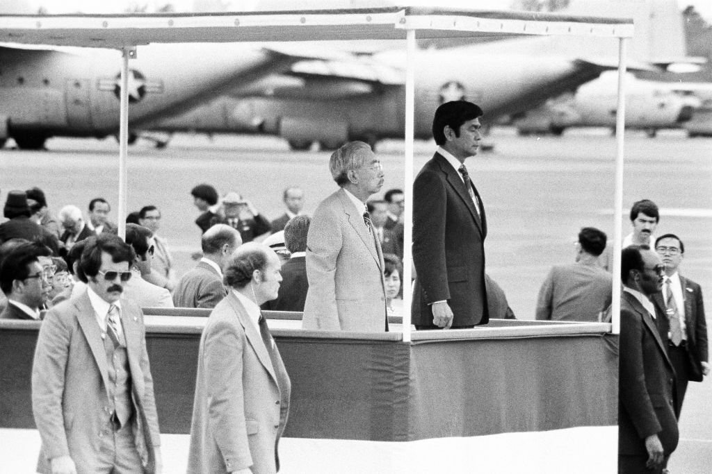 Emperor Hirohito attends the farewell ceremony with Hawaii Governor George Ariyoshi at Hickam Field on October 13, 1975 in Honolulu, Hawaii.