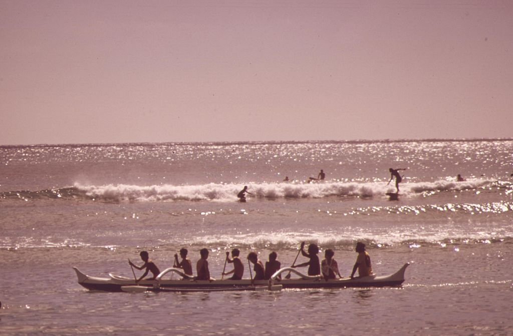 Outrigger canoes and surfers at Waikiki Beach, Honolulu, Hawaii, October, 1973.