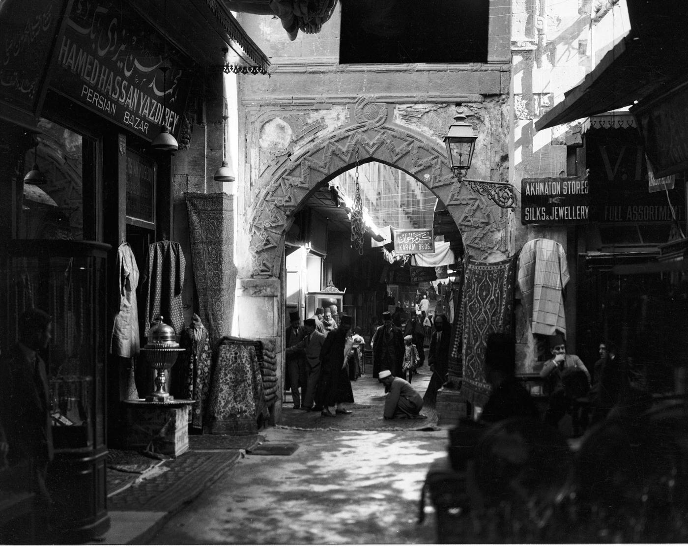 People gather on both sides of an archway at a bazaar in Cairo, Egypt, 1940