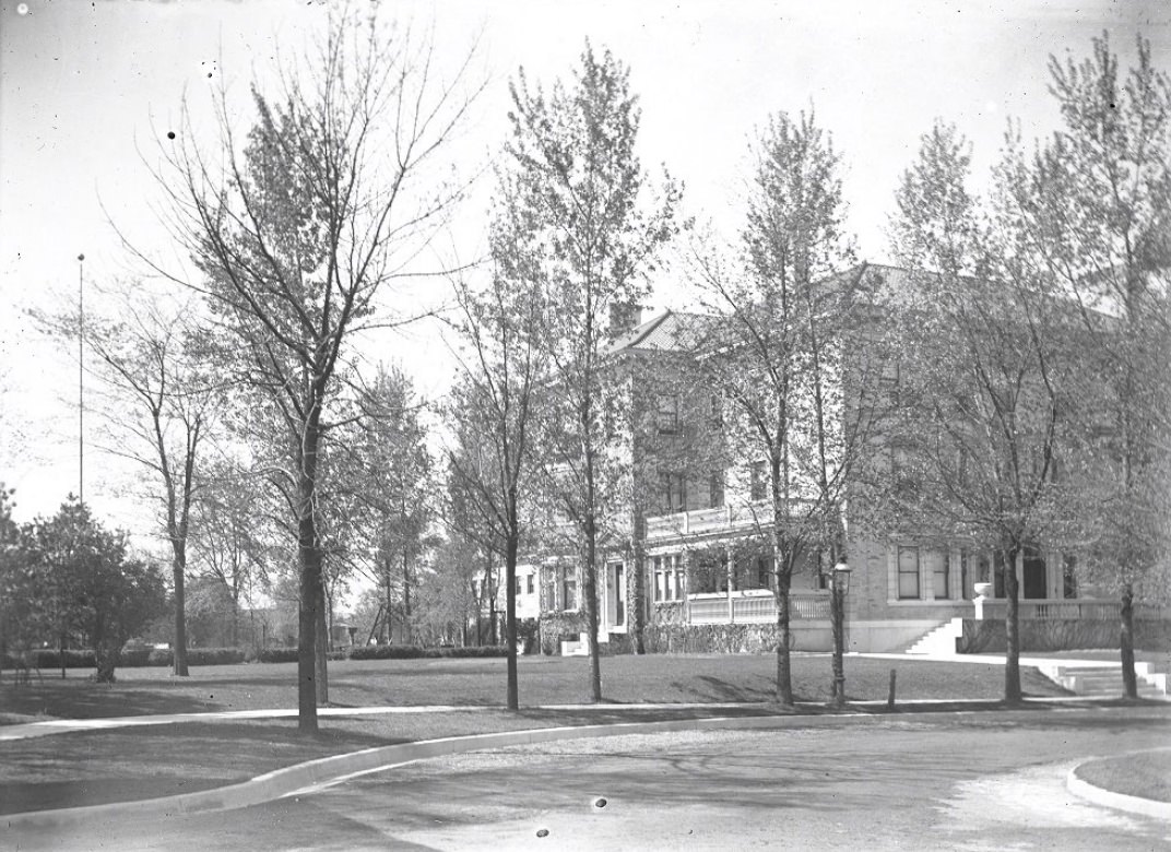 Street view photograph of large homes in a suburban area, 1900.