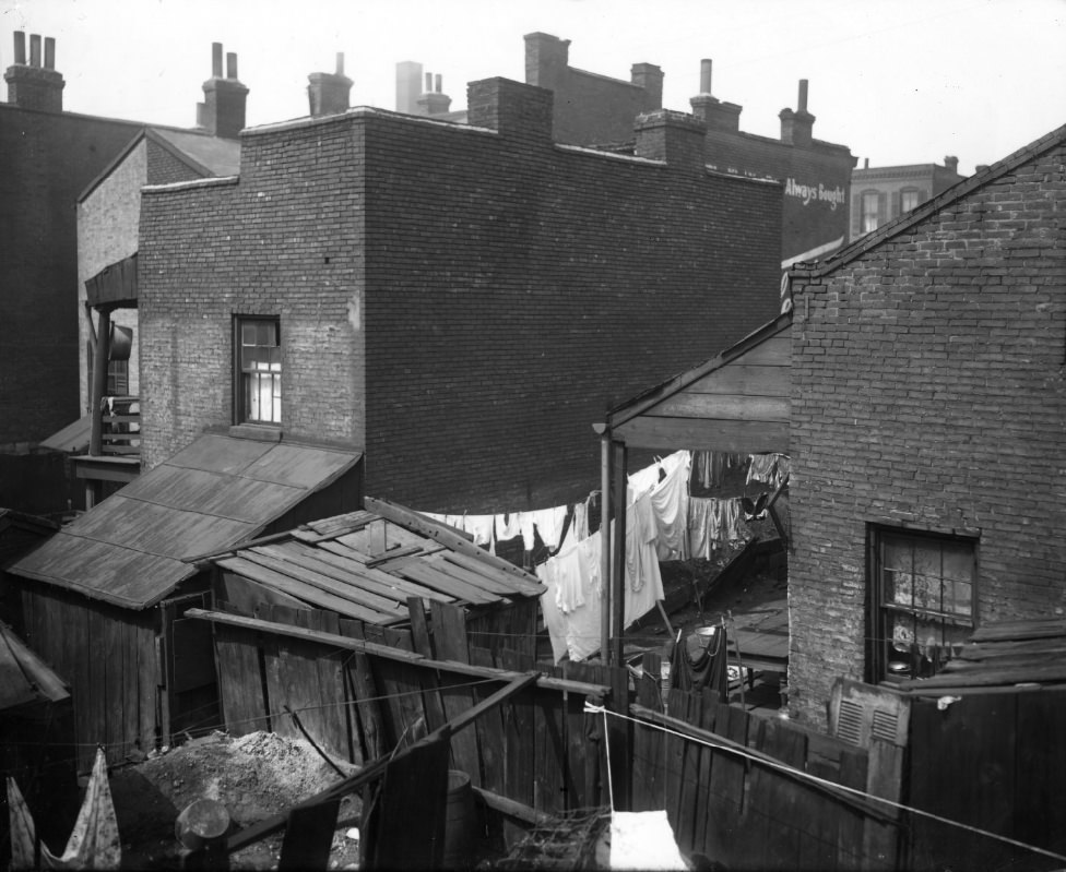 Rear of urban residential housing showing laundry drying, 1900