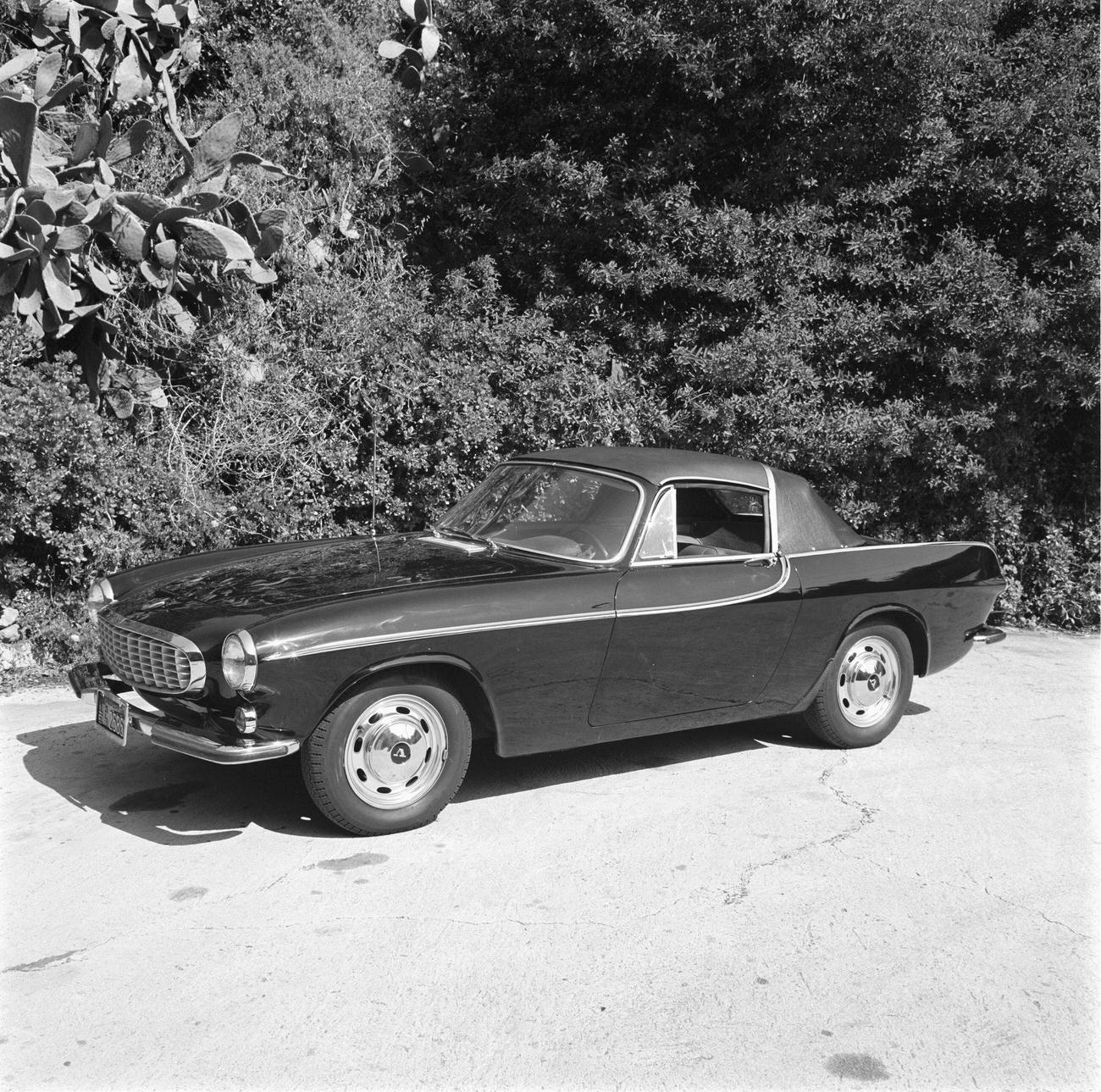 Volvo P1800 with a removable vinyl-covered hardtop over the front seats and a convertible top over the rear seat.