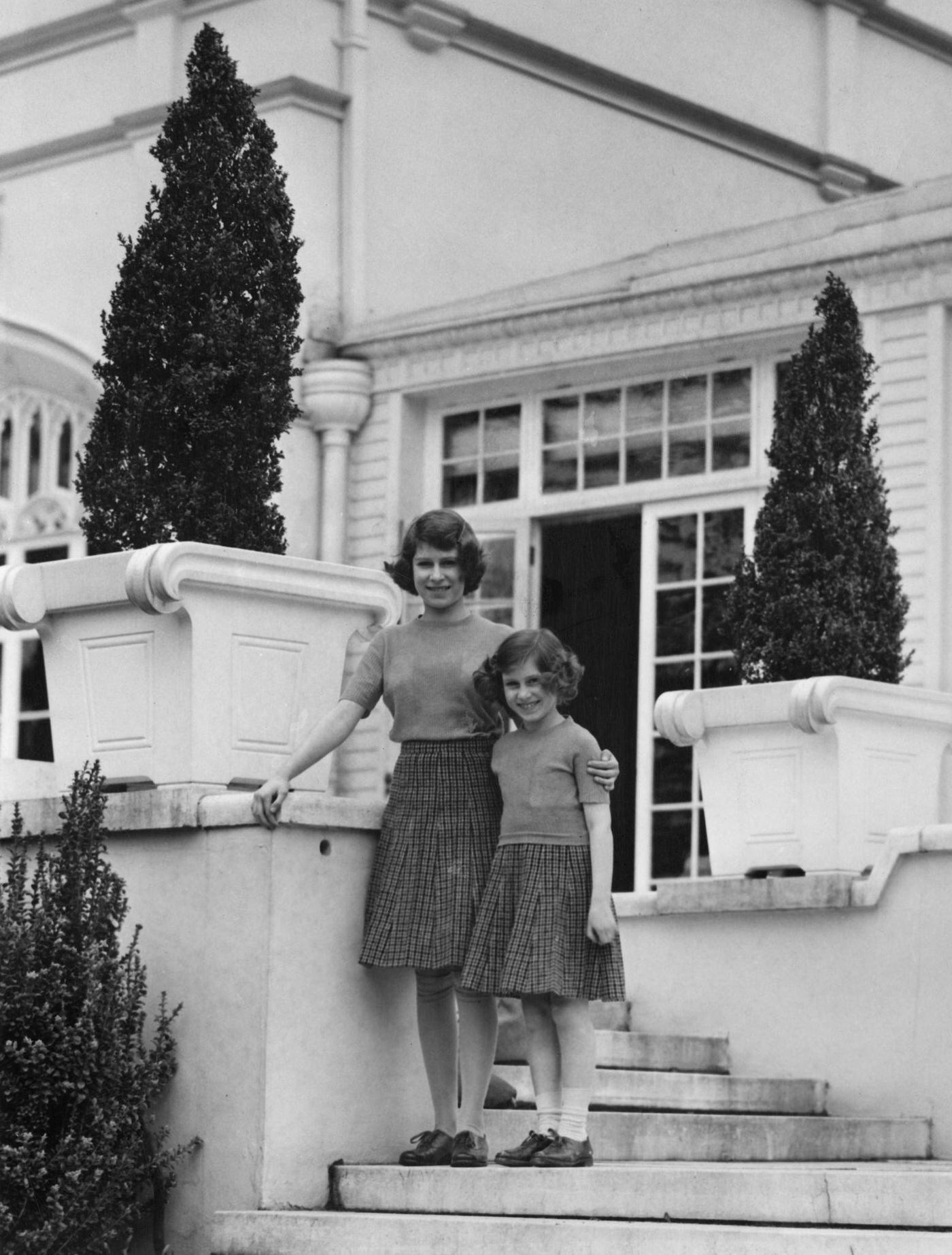 Princess Elizabeth (now Queen Elizabeth II, left) with her younger sister Princess Margaret Rose on the terrace steps at the back of the Royal Lodge in Windsor Great Park, April 1940.