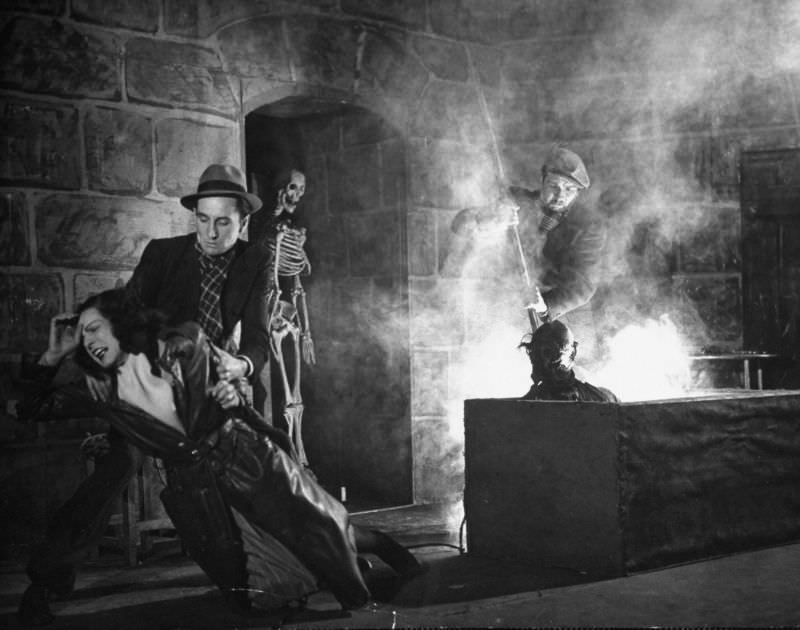 Actors demonstrating use of the acid vat to make skeletons in production trick at the Grand Guignol Theater.