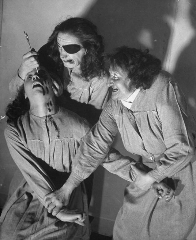 Actors engaging in an eye-gouging scene in a bloody melodrama production at the Grand Guignol Theater.