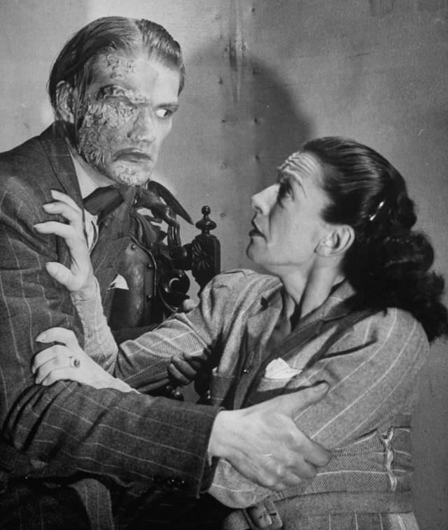 Actors reenacting scene with frightened woman and a man with facial burns, in production at the Grand Guignol Theater.