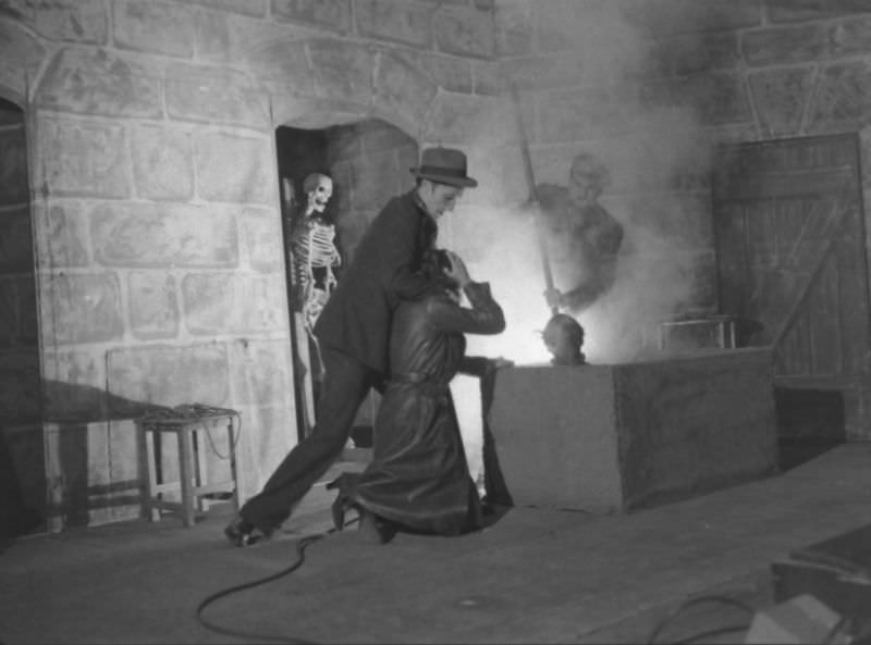 Actors demonstrating use of the acid vat to make skeletons in production trick at the Grand Guignol Theater.