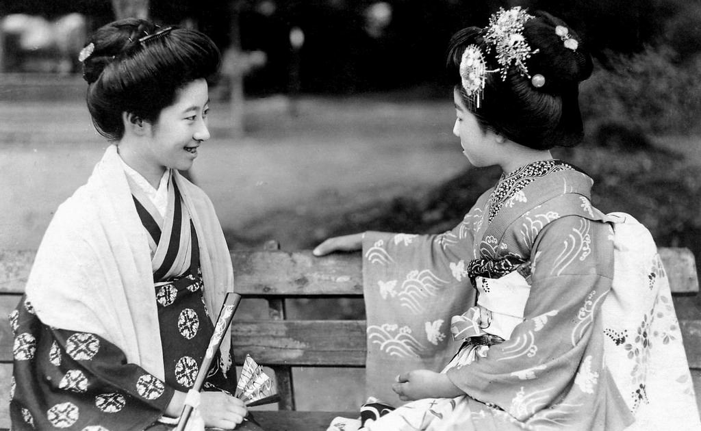 Two young girls sitting on a park bench, 1920s