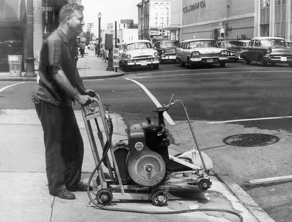 Gordon Burks, an electrician for Union Electric Co. Inc., used a new machine to saw out segments of sidewalk in downtown Richmond, where the company was replacing traffic lights, 1961.