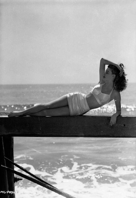 Nữ diễn viên Ava Gardner nằm dài trên cầu tàu gỗ trong bộ bikini thanh lịch, tháng 3/1943.