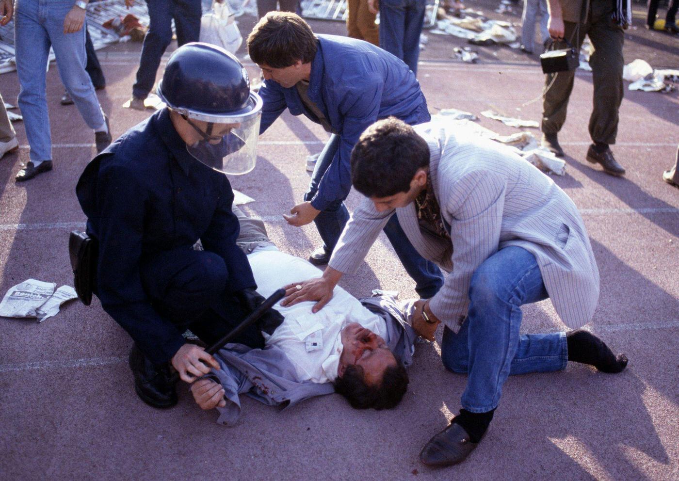 Riot police try to revive an injured fan at Heysel Stadium, European Cup Final, 1985.