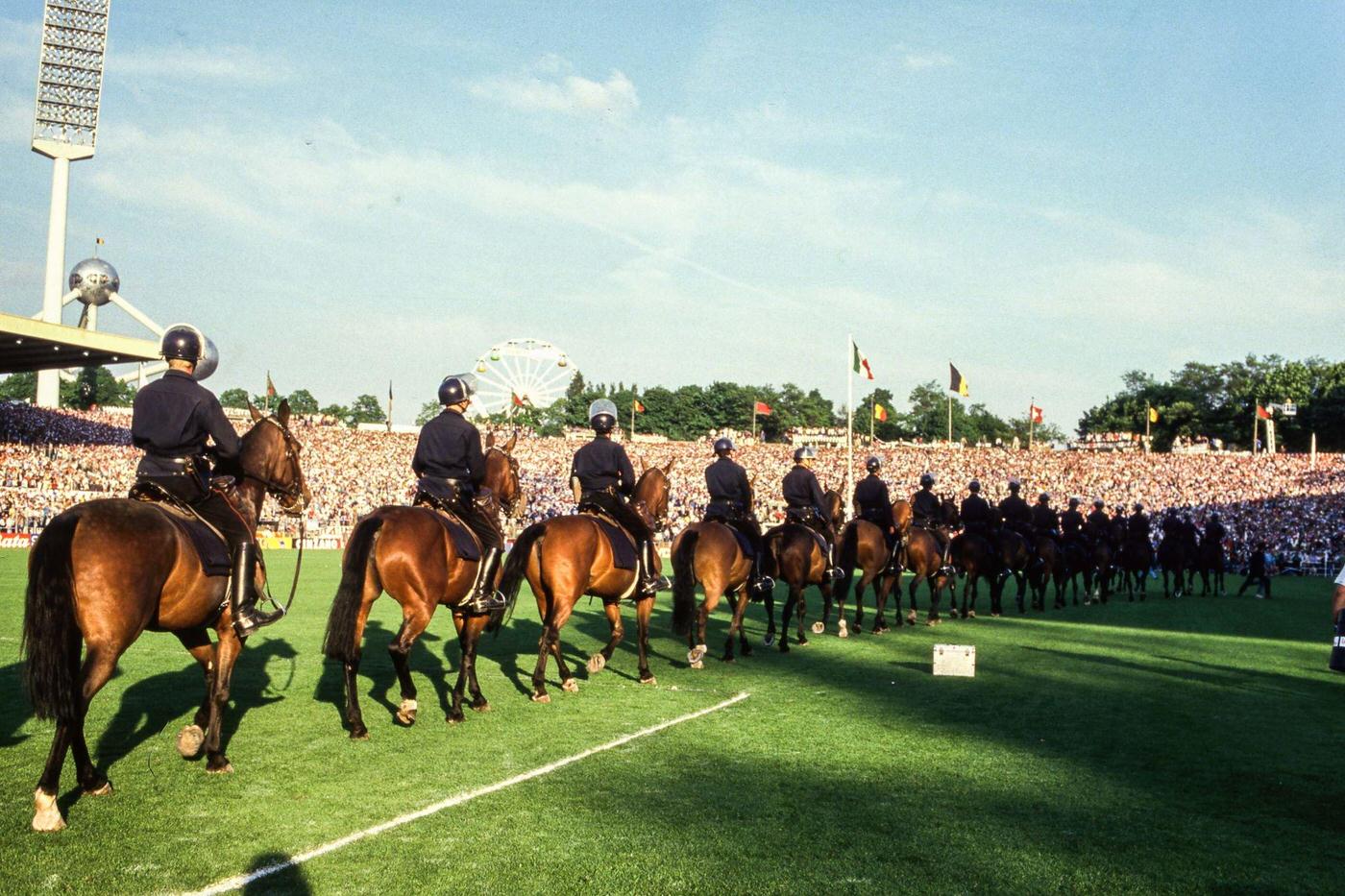 Mounted police patrol pitch side during European Cup Final at Heysel Stadium, 1985.