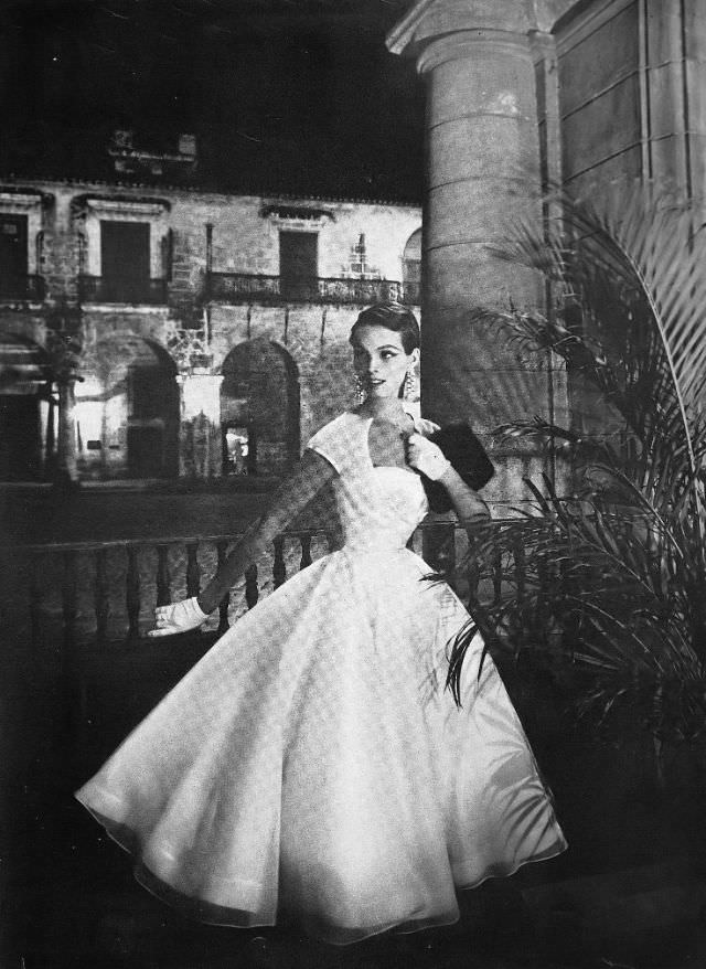 Linda Harper in a white satin dress with a single red rose by Jo Copeland, Havana, 1954.