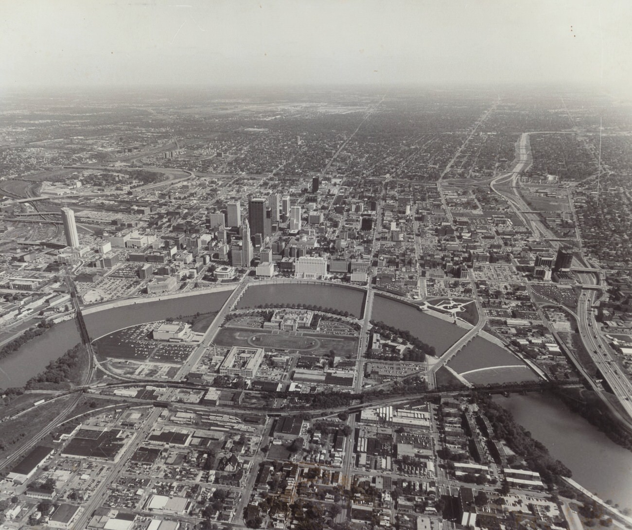 Aerial view of the Scioto River and downtown Columbus, featuring Nationwide building and Franklin County Jail, 1970s