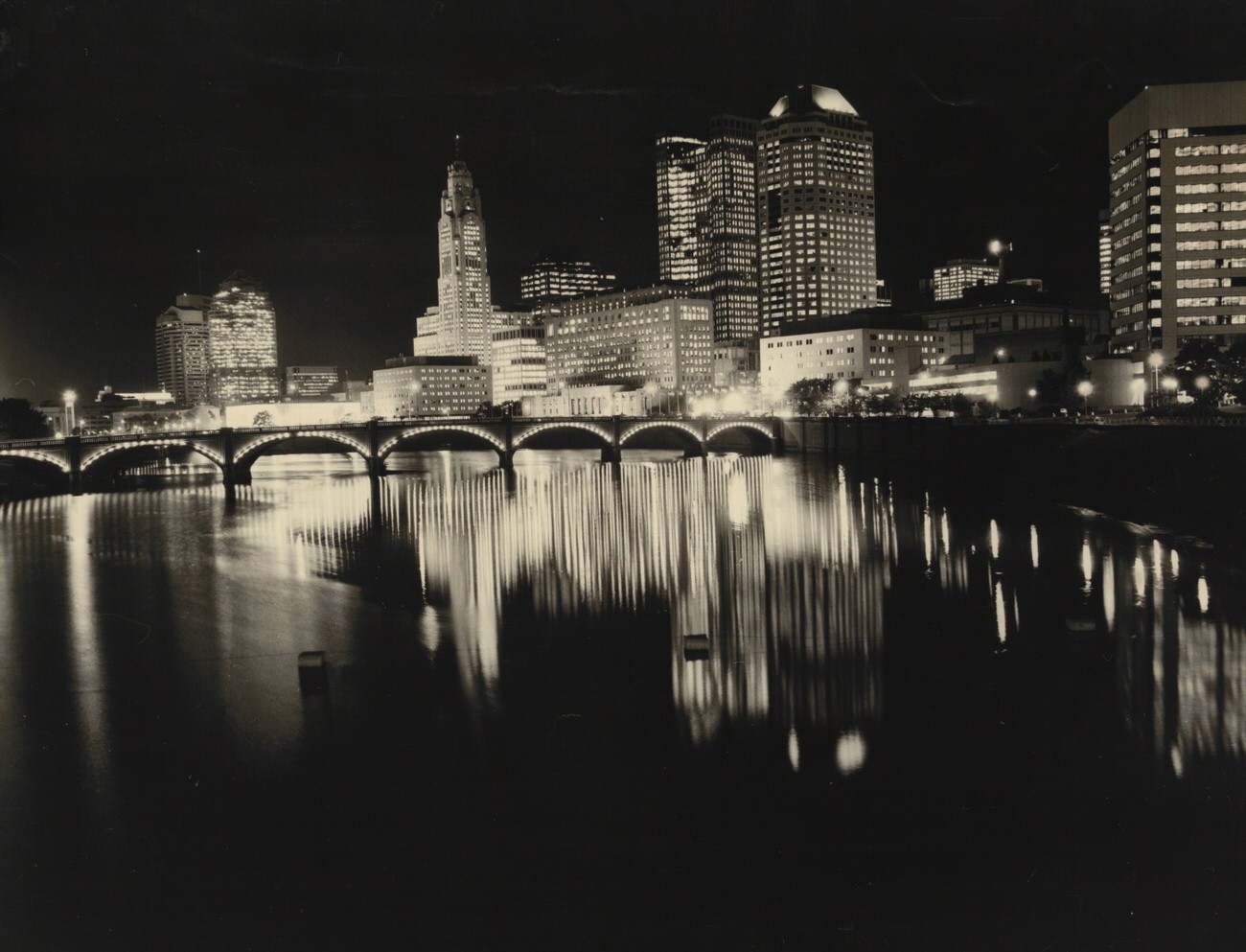 Night view of downtown Columbus riverfront and Scioto River, 1980s