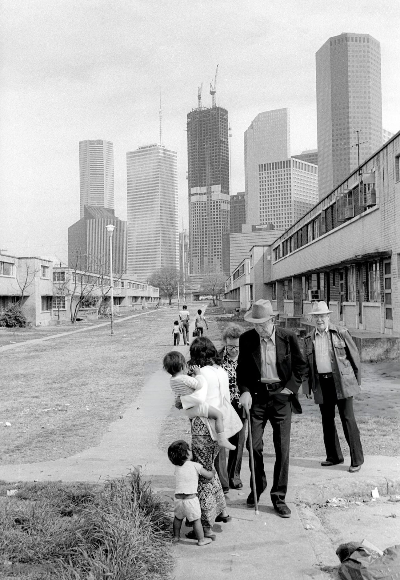 Elderly white seniors pass an Asian mother and her children, Houston, Texas, 1983.