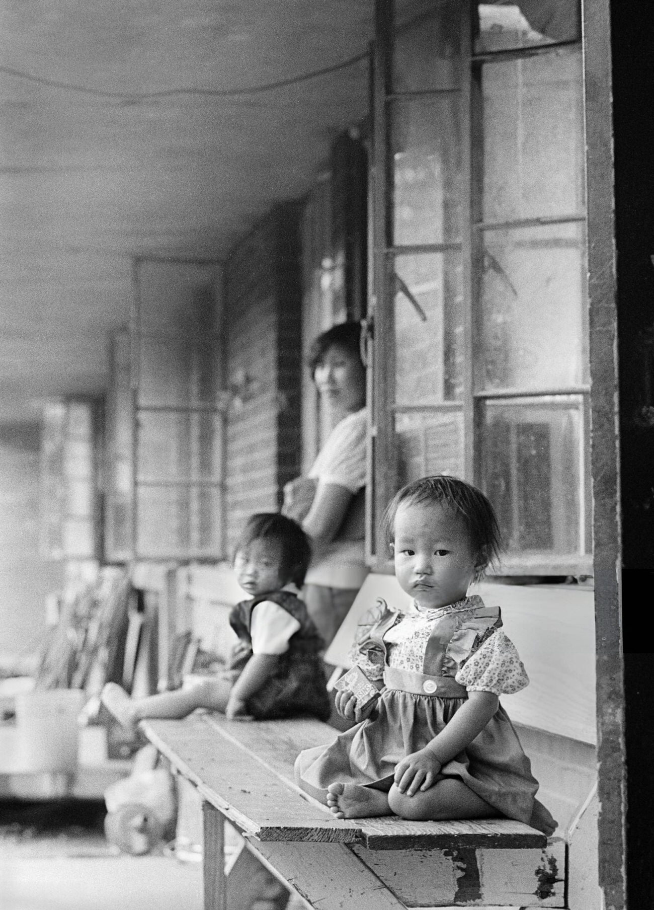 An Asian immigrant mother with her two daughters on their front porch, Houston, Texas, 1983.