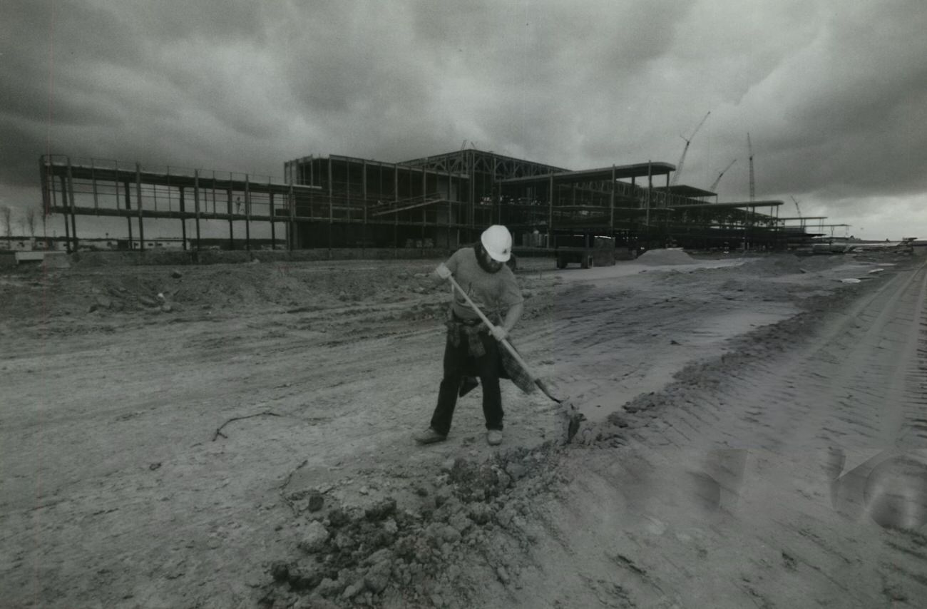 A worker uses a shovel during construction of Terminal D at Intercontinental Airport, Houston, 1980s