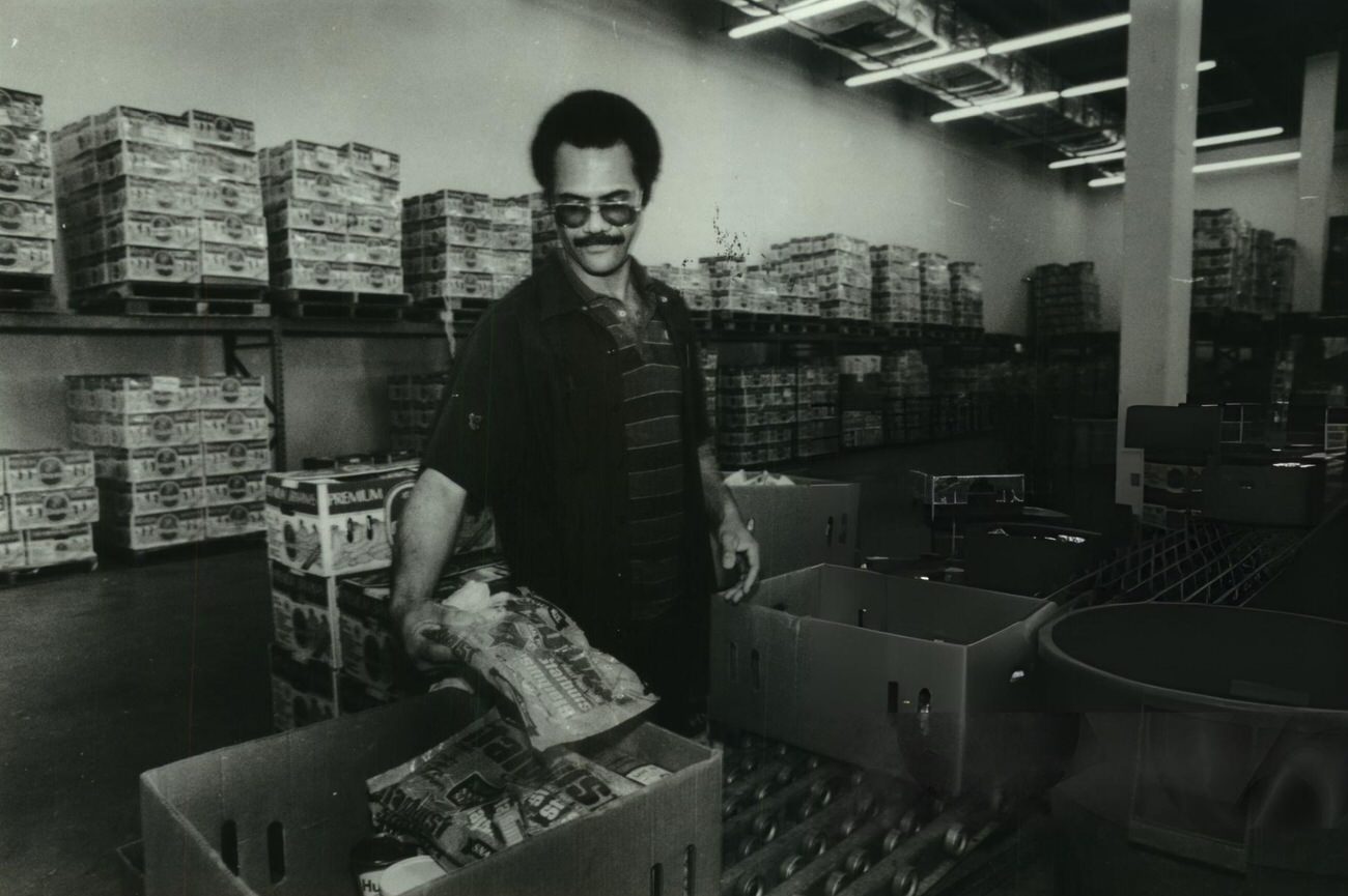 John Rowland sorts food at the Houston Food Bank, part of a pilot program targeting one of the city's poorest neighborhoods to eradicate hunger, Houston, 1980s