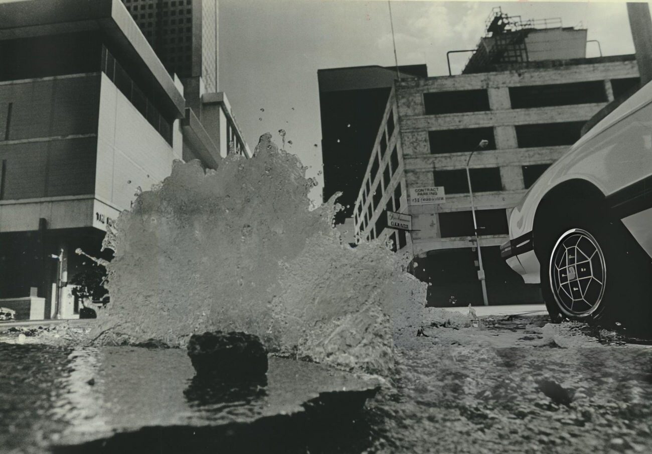 A water main break creates an unplanned fountain at Milam and Prairie streets, Houston, Texas.