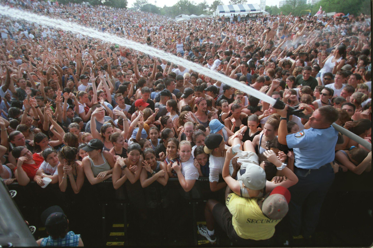 Firefighter cools down crowds at the Earth Day Festival in Buffalo Bayou Park, Houston, Texas, 1999.